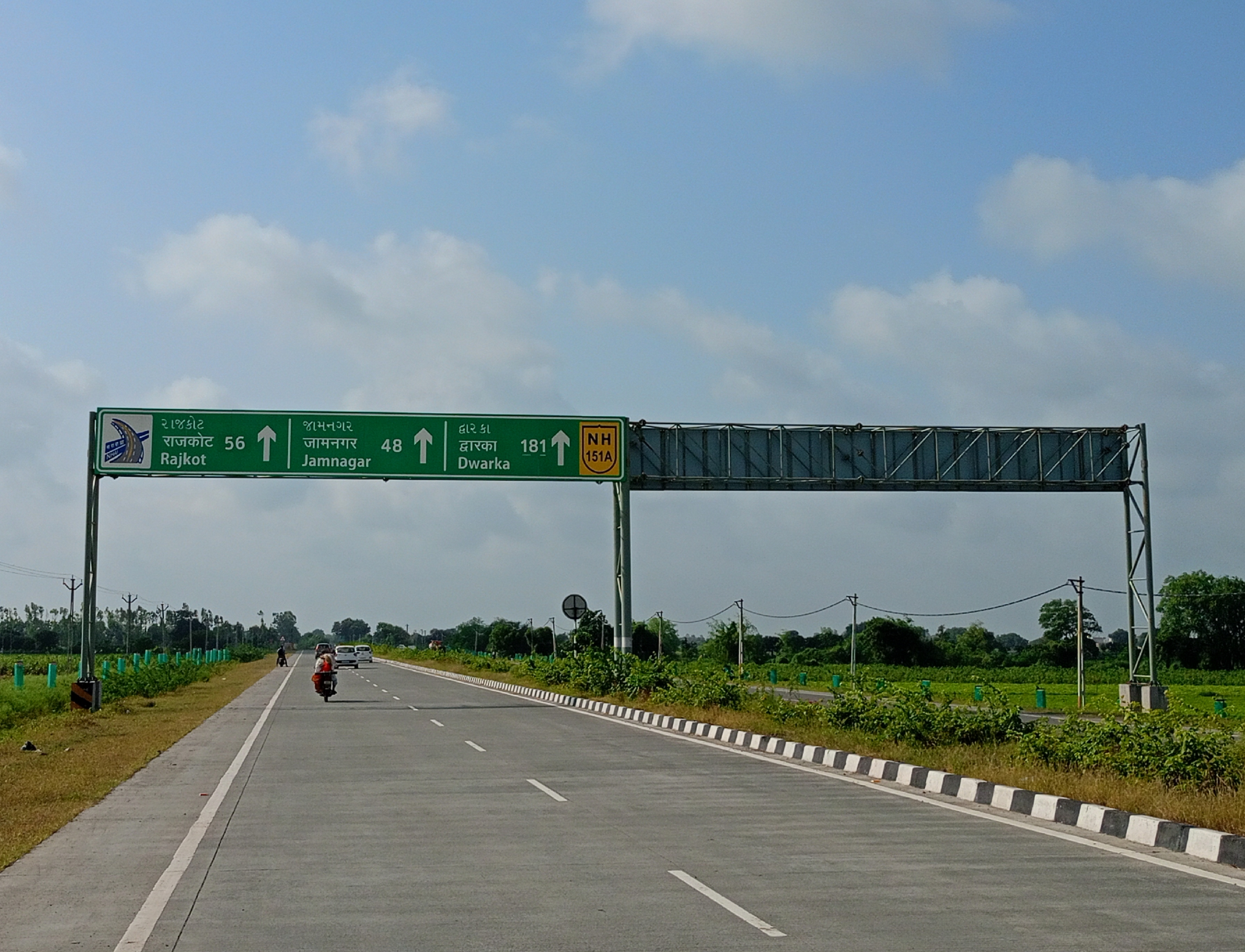 NH151A_signboard_at_lakhtar_village_boundary_in_jodiya