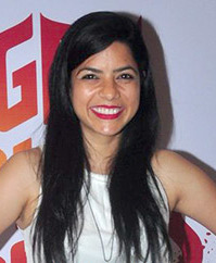 Rajshri Deshpande wearing a white, sleeveless top, grinning at camera