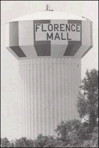 A black-and-white photo of a water tower with the words "Florence Mall" painted on it