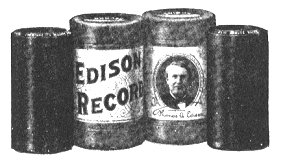 Two Edison cylinder records (left and right) and their cylindrical cardboard boxes (center)