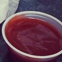 Reddish mumbo sauce in a small takeout container