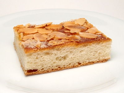 A slice of Butterkuchen, showing a yeasted dough base and almond topping