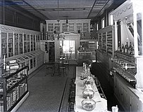 interior of an unidentified drugstore in Toledo, Ohio, United States, 1900s. A large cigar counter and a long bar with seating is featured. The photo was taken by Charles F. Mensing around 1900.