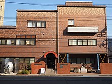 Color photograph of a three-story red brick building