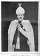 A photograph of a man stood wearing a turban, spectacles and the robes, star, sash and collar of the Order of the Star of India.