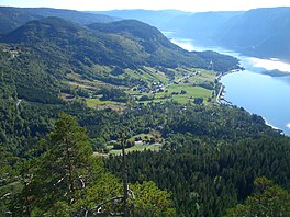 A lake in a valley with hills and trees surrounding it