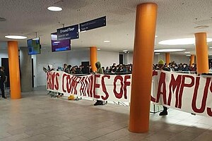 Occupation in The Diamond holding up a banner that reads "Arms companies off campus"
