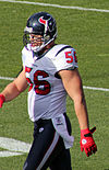 A picture of an American football player walking on a playing field