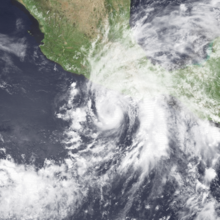 Satellite image of a broad tropical cyclone centered along the southwestern coast of Mexico