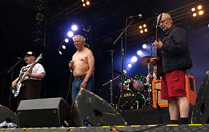 All four members performing on a stage.