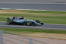Photo of Lewis Hamilton driving a silver Mercedes on a racetrack