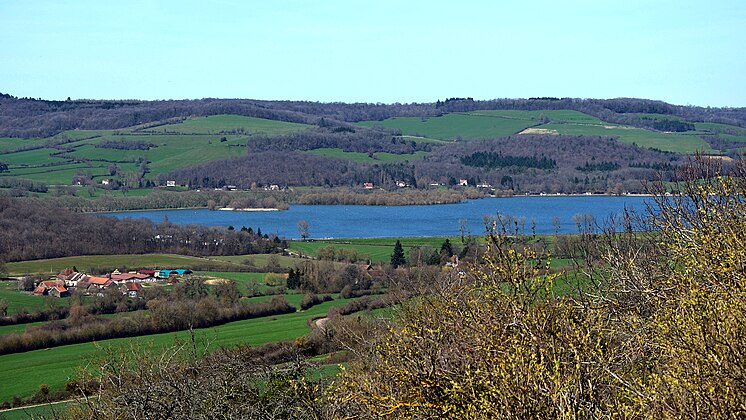 Le lac de Panthier vu depuis Châteauneuf.La rive opposée est essentiellement sur Créancey. De l'autre côté du lac, deux petits monts entièrement recouverts de bois : le Petit Montot (butte de gauche, ~420 m d'alt.) sur Créancey et à sa droite le Grand Montot (446 m d'alt.) sur Semarey, commune non limitrophe du lac. Les berges à droite derrière les arbres sont sur Commarin. Sur l'avant à gauche, le hameau des Bordes sur Vandenesse.