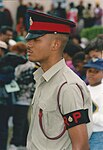 Royal Bermuda Regiment Regimental Policeman in No. 2 Dress khaki shirt, without tie, and No. 1 Dress cap.