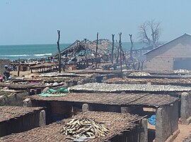 Peixes sendo defumados nos telhados de cabanas na vila de Tanji