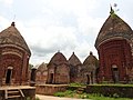 A cluster of small Indian-style terracotta temples with domed roofs