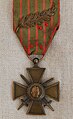 Médaille avec une croix chargée de deux épées en sautoir, au bout d'un ruban vert rayé de rouge