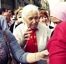 Photographie d'une femme âgée parlant dans un micro