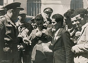 יהודים תוניסאים תולשים מבגדיהם את הטלאי הצהוב מול חיילי בעלות הברית ששחררו את תוניסיה משלטון צרפת של וישי ב-13 במאי 1943
