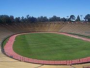 A view of Stanford Stadium from the stands, showing the pitch encircled by a running track