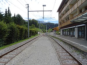 Station building next to a single-line track with a passing loop