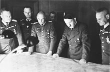Photograph of Halder standing on Adolf Hitler's left side looking at a map with four other officers
