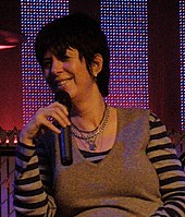 Diane Warren holding a mic.