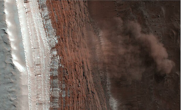 Avalanche déclenchée par le dégel dans la calotte polaire et photographiée en février 2008. Le nuage de débris fait environ 200 mètres de long et la falaise a une hauteur de 700 mètres et pente d'environ 60°. Sa partie supérieure est couverte de dioxyde de carbone gelé.