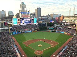 A baseball scoreboard with a skyline in the background