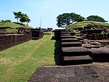 Ancient remains of stone walls with a grassy path in the middle