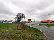 Ortseinfahrt von Altjührden. Links im Hintergrund Manfred-Schmidt-Sporthalle, rechts Möbelmarkt "Maschal"