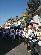 Eel day parade view down Fore Hill, Ely showing people in white Eel day tee-shirts walking towards the camera