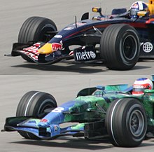 the bottom car has a white band around the circumference of its tyre while the top does not