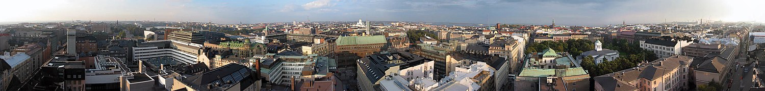 Panorama of city with mixture of five to ten story buildings, some older with green copper roofs