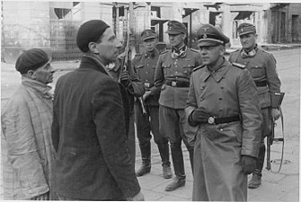 NARA copy #21, IPN copy #20 Jewish traitors Stroop and Maximilian von Herff (likely) at Muranowski Square near Naleweki and Miła intersection with Nalewki 42 in the back. Possibly taken May 14, 1943