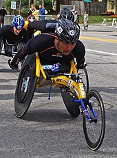 A photo of Masazumi Soejima, in a wheelchair, racing on the road