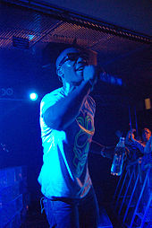 A picture of a man wearing sunglasses and singing into a microphone