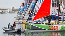 Le monocoque aux côtés des autres monocoques de la Class40 dans le bassin Paul Vatine du Havre. Les deux skipper discutent à bord du voilier.