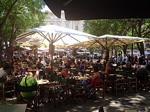 Août 2014, vue des terrasses de cafés ombragées sur la place.