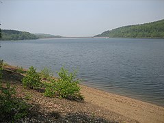 Blick über den See, im Hintergrund der Damm.