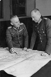 Photograph of Franz Halder looking at Walther von Brauchitsch who is standing to Halder's left as they study a map