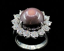 An 11.26 ct. deep purple quahog pearl, diamond, and platinum ring