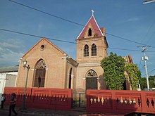 Red brick church with a Celtic cross on top