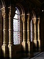 Windows behind the main staircase, The Natural History Museum, Romanesque round windows, note the colonettes with their carved capitals and elaborately decorated shafts, also typical Waterhouse window glass in geometric patterns and shades of pink and blue