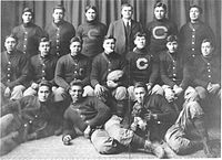 The 1911 "Carlisle Indians" football team pose with a game ball from the upset of Harvard. Coach "Pop" Warner (standing, third from right) and Jim Thorpe (seated, third from right) are pictured.