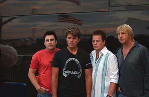 The four members of Lonestar, standing in front of their tour bus.