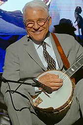 A man wearing a suit and playing a banjo.