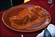 Bacalao a la Vizcaína y su característica salsa de pimiento choricero.