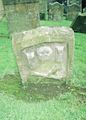 An old tombstone with skull, cross-bones and a timer