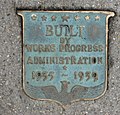 A plaque embedded in the sidewalk of the page contains a WPA logo