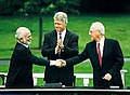 A handshake between King Hussein and PM Rabin, accompanied by President Clinton, during the Israel-Jordan peace negotiations, 25 July 1994